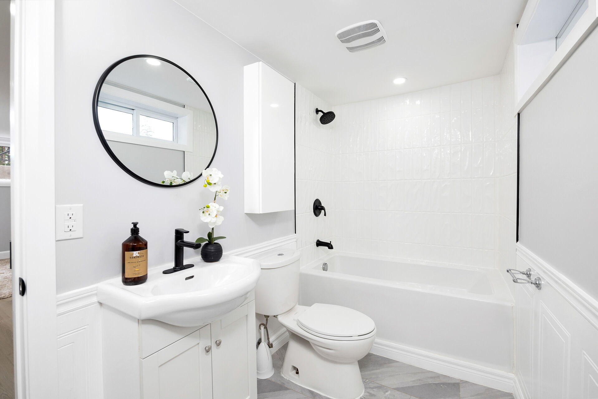 Full bathroom with white tub surround and black shower fixtures.