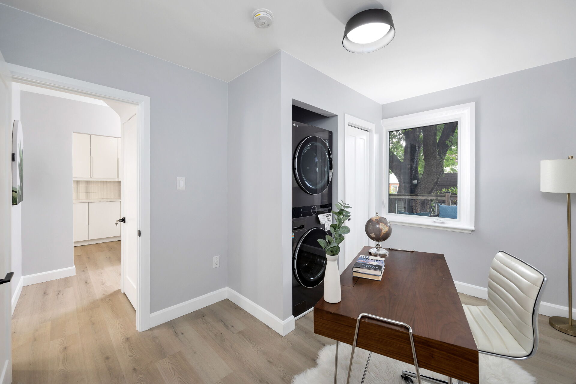 Flexible bedroom or home office with a closet beside a stacked in-unit washer and dryer.